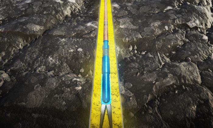 Uma ferramenta agrícola com um cabo azul e uma extremidade em forma de forquilha é apresentada num sulco delineado a amarelo num campo de terra.