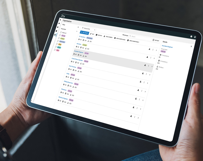 Uma pessoa com um tablet que apresenta uma aplicação de gestão de tarefas com uma lista de tarefas e respectivos estados.