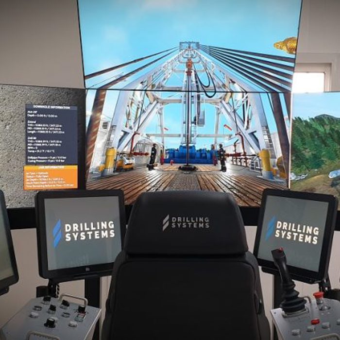 A control station with multiple displays and monitors labelled "Drilling Systems," showing detailed graphics and information related to drilling operations.