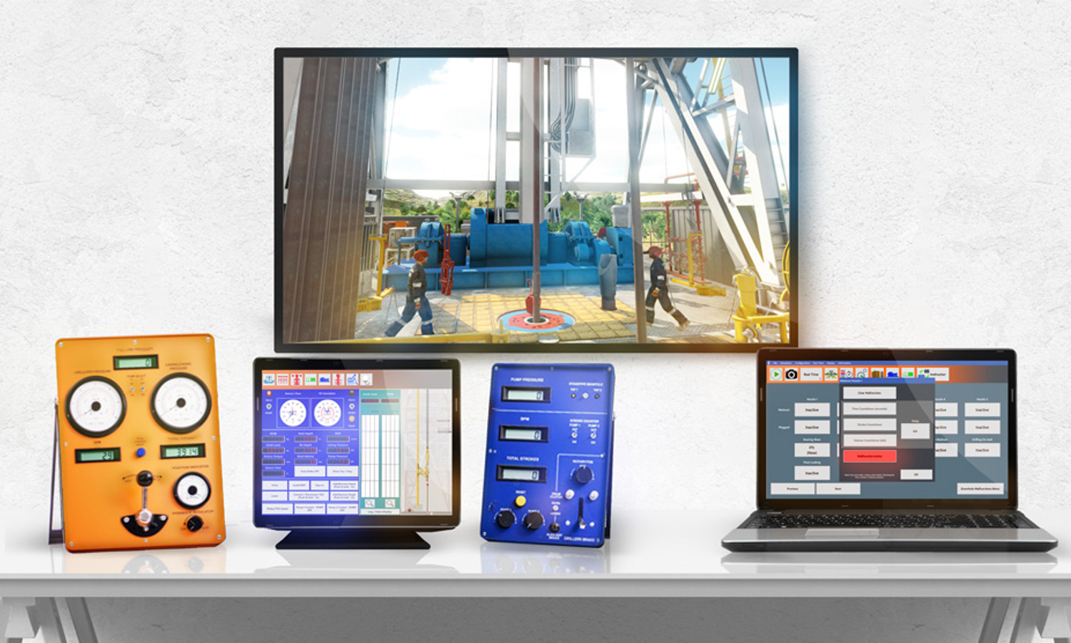 Uma secretária apresenta um monitor que mostra uma cena industrial, ao lado de um dispositivo laranja, um tablet com um ecrã azul, um dispositivo azul com botões e um computador portátil com uma interface em grelha.