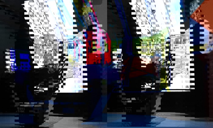 A configuração de um simulador inclui um grande ecrã que apresenta o equipamento, uma cadeira de controlo e vários monitores.